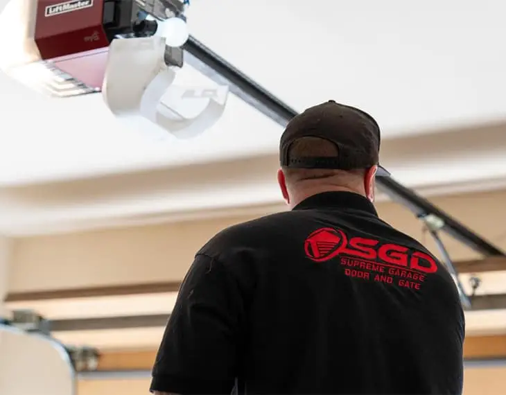 Supreme Garage Door Repair technician inspecting a LiftMaster opener during service in Dallas