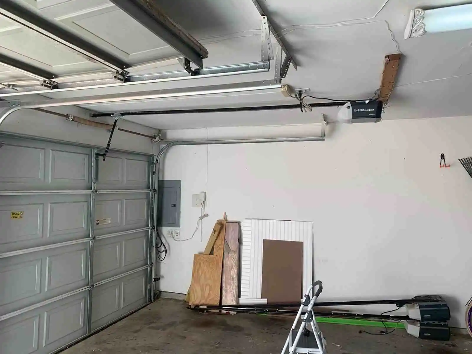 Interior view of a two car residential garage featuring two sectional doors with a ceiling mounted LiftMaster automatic opener in Dallas